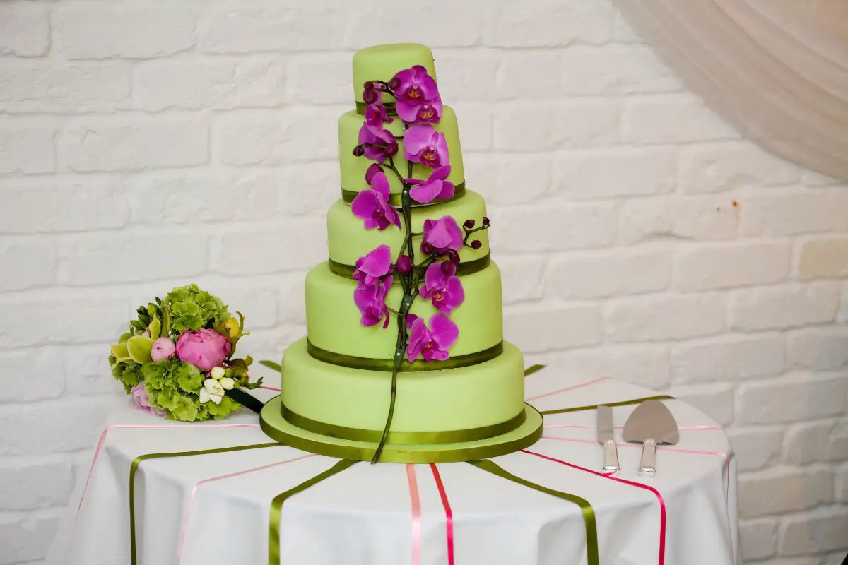 A big cake surrounded by a lot of roses