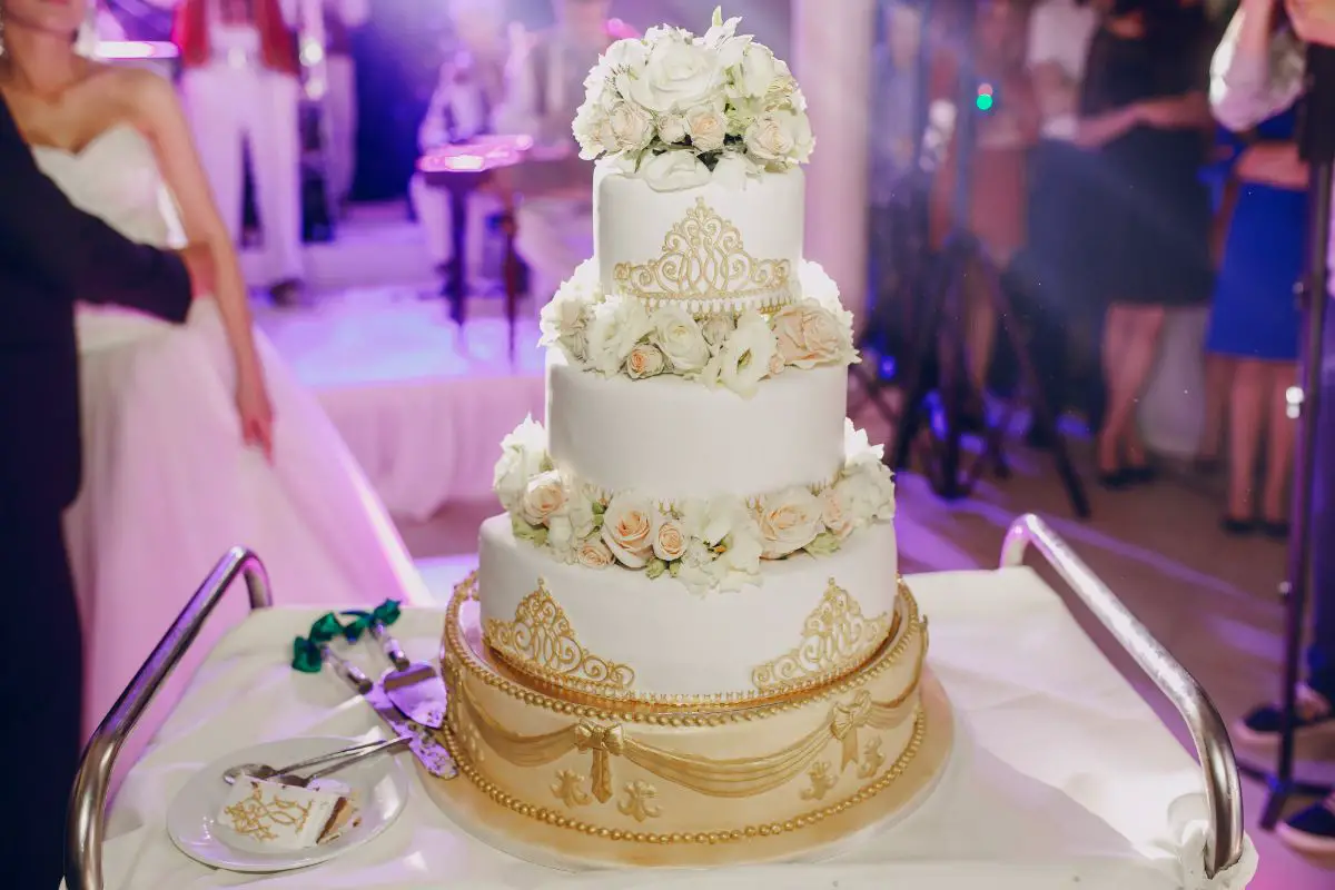 Three-tier wedding cake with floral display and candles Stock Photo - Alamy